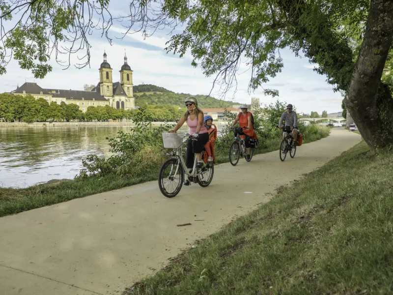 Famille à vélo sur le halage de la Moselle à Pont-à-Mousson devant l'abbaye des Prémontrés