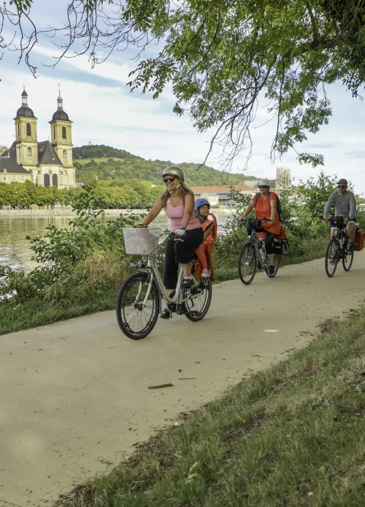 Famille à vélo sur le halage de la Moselle à Pont-à-Mousson devant l'abbaye des Prémontrés
